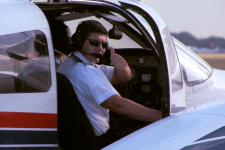 Shot of Aerosim flight instructor taxiing by with a thumbs up out of the door of a Piper Seminole.